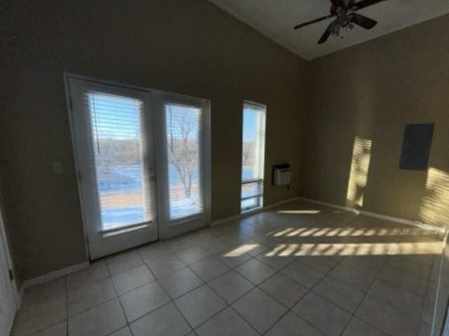 empty room with light tile patterned floors, baseboards, and ceiling fan