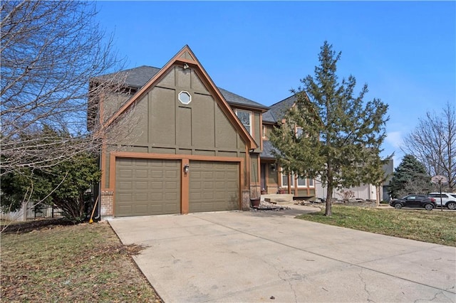 tudor home featuring roof with shingles, brick siding, concrete driveway, a front lawn, and board and batten siding