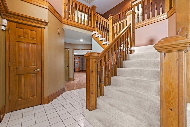 stairs with tile patterned floors and baseboards