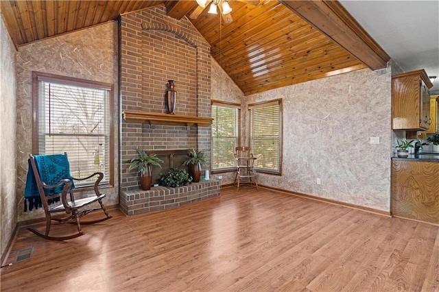 living area with visible vents, beam ceiling, high vaulted ceiling, a ceiling fan, and wood finished floors