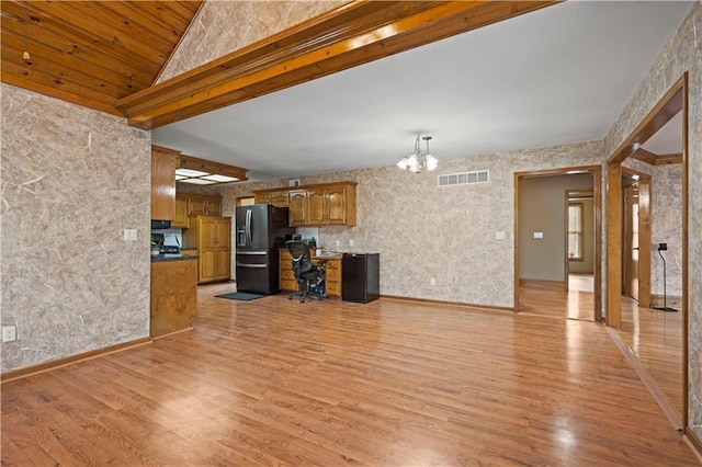 kitchen featuring visible vents, a chandelier, light wood-style floors, brown cabinetry, and black fridge with ice dispenser