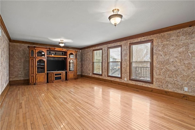 unfurnished living room with light wood finished floors, baseboards, and ornamental molding