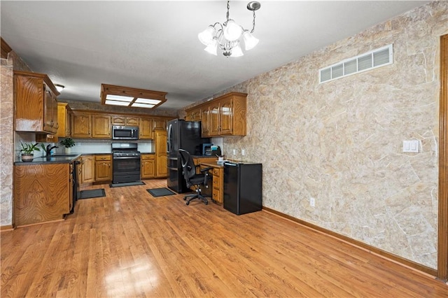 interior space featuring a chandelier, visible vents, light wood-style floors, and a sink