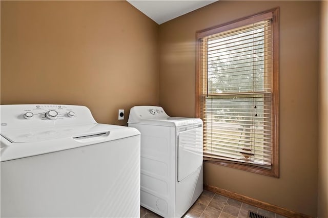 clothes washing area with laundry area, independent washer and dryer, visible vents, and baseboards