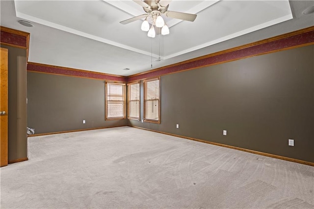 carpeted spare room with baseboards, a raised ceiling, and ceiling fan