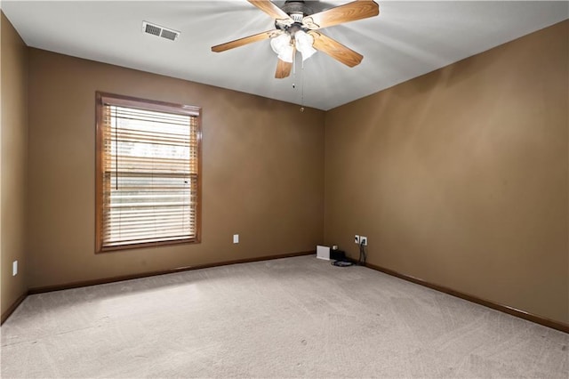 empty room with visible vents, baseboards, light colored carpet, and ceiling fan