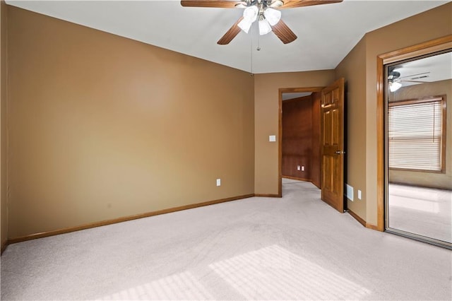 unfurnished bedroom featuring baseboards, light carpet, and a ceiling fan