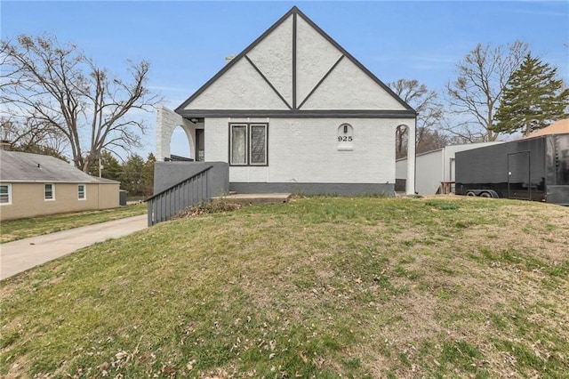 exterior space with brick siding and a yard