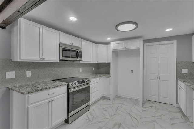 kitchen featuring light stone counters, marble finish floor, white cabinets, and stainless steel appliances