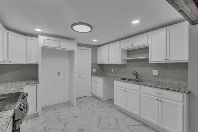 kitchen with light stone countertops, a sink, white cabinets, electric stove, and marble finish floor