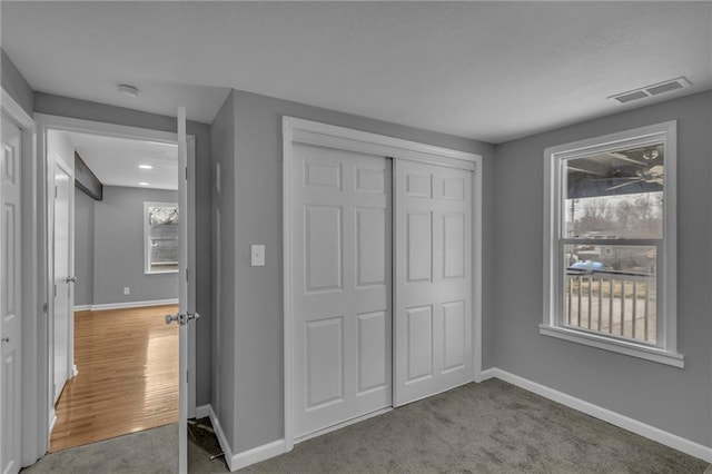 unfurnished bedroom featuring a closet, baseboards, visible vents, and carpet floors