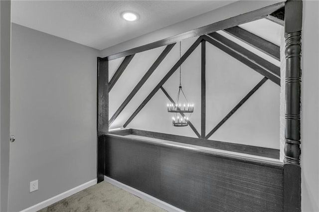 room details featuring baseboards, beam ceiling, a chandelier, and carpet flooring