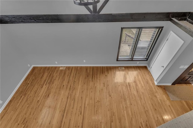 interior space with visible vents, wood finished floors, and baseboards