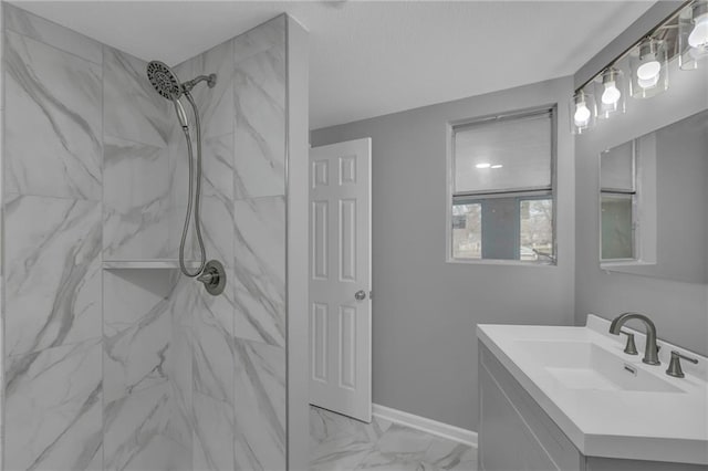 bathroom featuring vanity, baseboards, marble finish floor, and a marble finish shower