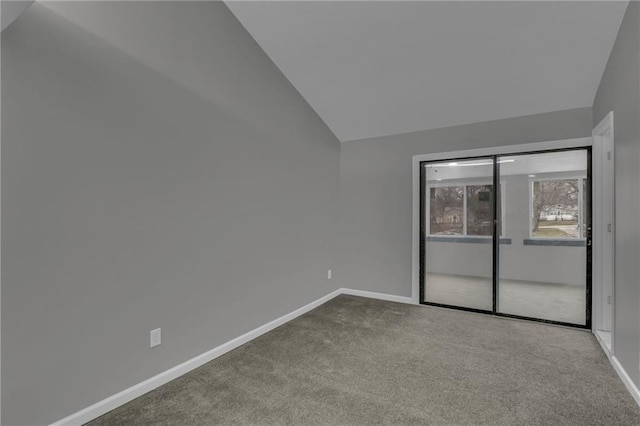 carpeted spare room with baseboards and lofted ceiling