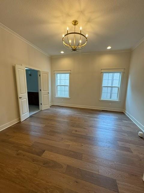 unfurnished room featuring baseboards, an inviting chandelier, dark wood-style floors, and ornamental molding