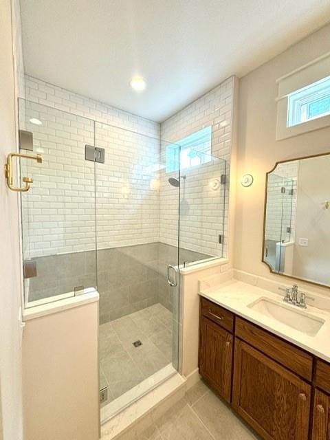 full bathroom featuring vanity, tile patterned floors, and a shower stall