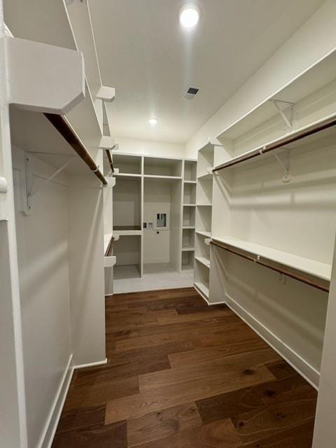 walk in closet with dark wood finished floors and visible vents