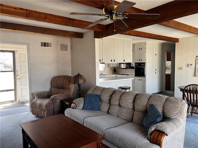 living room with visible vents, beamed ceiling, carpet flooring, and a ceiling fan