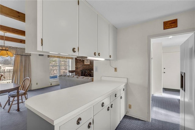 kitchen featuring carpet floors, white cabinets, a fireplace, and light countertops