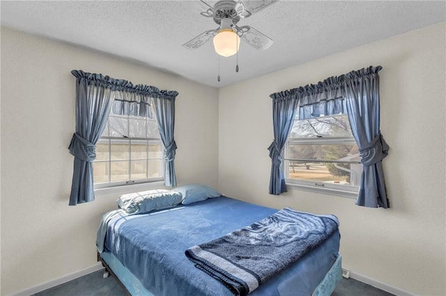 bedroom featuring multiple windows, carpet, and a textured ceiling