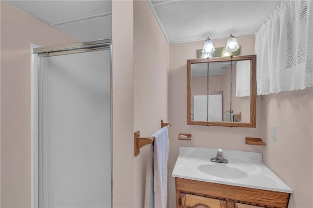 full bath featuring a shower with door and vanity