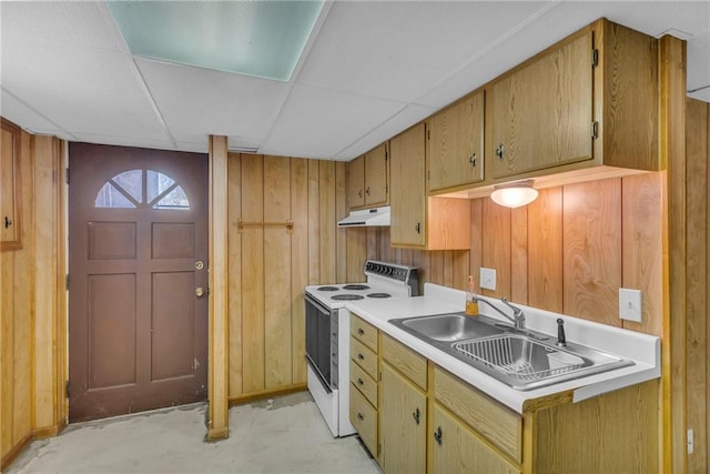 kitchen with white electric range, under cabinet range hood, wood walls, and a sink