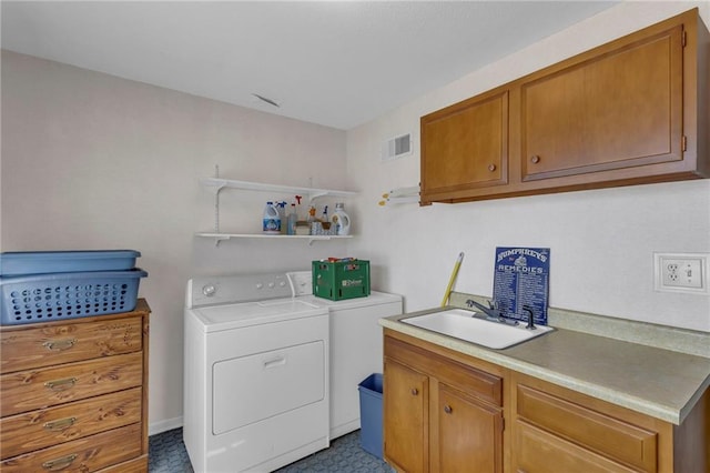 washroom featuring a sink, visible vents, cabinet space, and washer and dryer