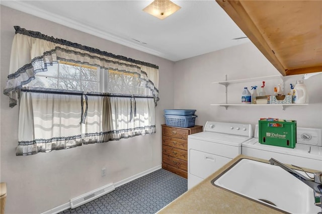 laundry area with baseboards, visible vents, laundry area, a sink, and washer and clothes dryer