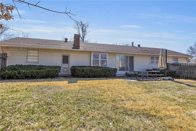 rear view of property featuring a patio area, a lawn, a chimney, and fence