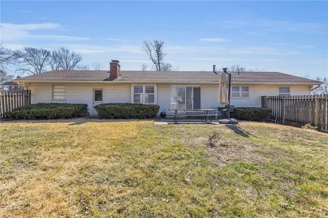 back of property featuring a patio area, a yard, fence, and a chimney