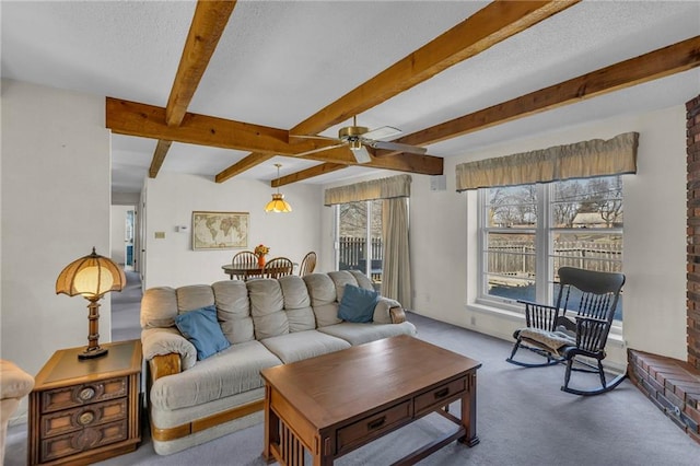 living room featuring beamed ceiling, carpet, a ceiling fan, and a textured ceiling