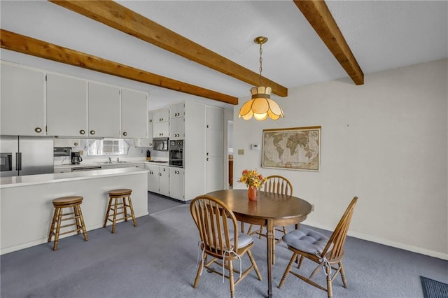 dining room featuring beam ceiling, baseboards, and dark carpet