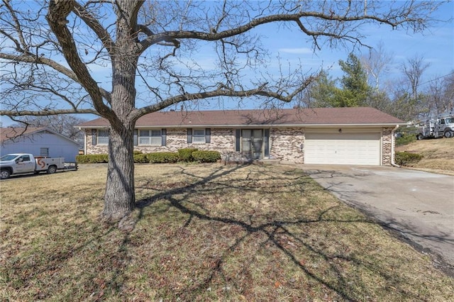 ranch-style house featuring a front lawn, a garage, and driveway