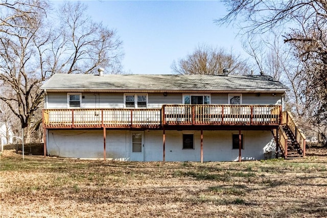 back of property featuring stairway, a lawn, and a wooden deck