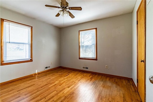 unfurnished room featuring visible vents, baseboards, light wood-style floors, and a ceiling fan