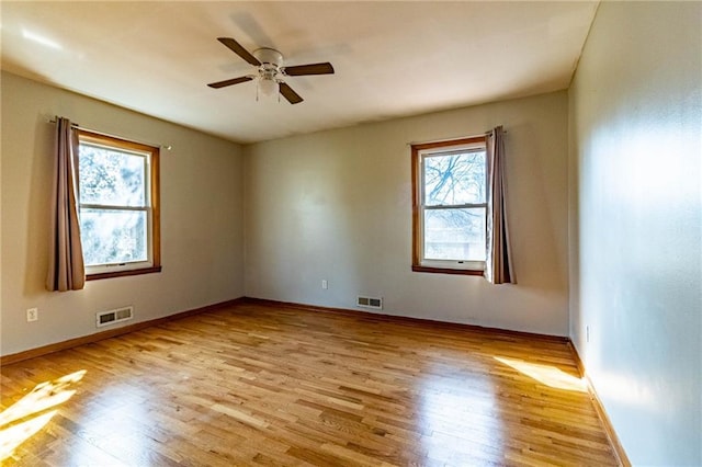 unfurnished room featuring visible vents, light wood-style flooring, and ceiling fan