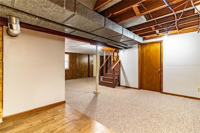 below grade area with baseboards, wood finished floors, and stairs