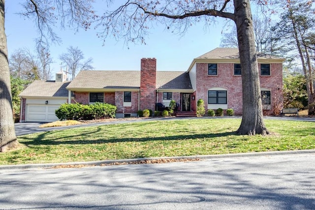 view of front of property with a front yard, an attached garage, brick siding, and a chimney