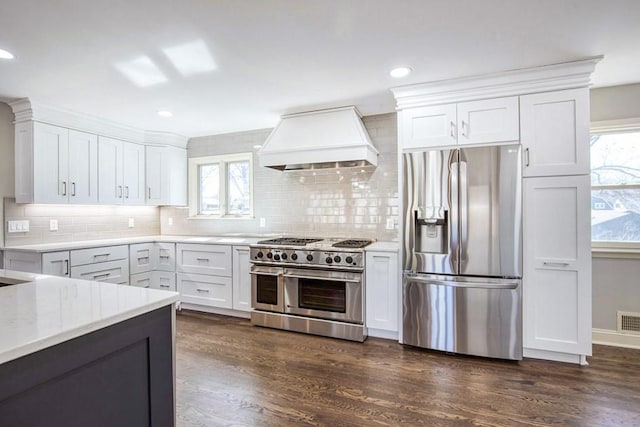 kitchen with dark wood-style flooring, white cabinetry, stainless steel appliances, and premium range hood