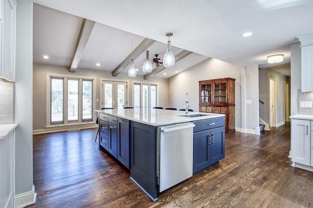 kitchen featuring dark wood finished floors, blue cabinetry, a sink, light countertops, and dishwasher