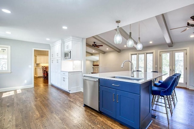 kitchen with appliances with stainless steel finishes, french doors, ceiling fan, and a sink