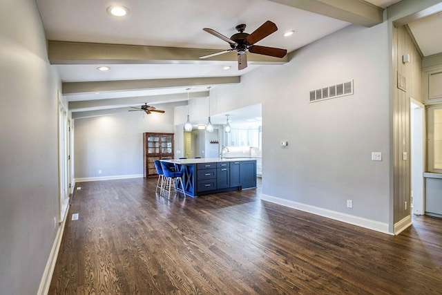 unfurnished living room featuring visible vents, ceiling fan, dark wood finished floors, lofted ceiling with beams, and a sink