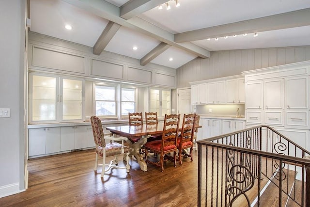 dining room featuring vaulted ceiling with beams and wood finished floors