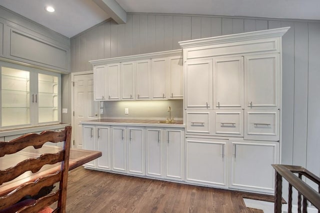 kitchen with lofted ceiling with beams, dark wood-type flooring, white cabinets, and light countertops