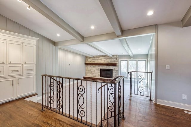 hall with beamed ceiling, an upstairs landing, baseboards, and dark wood-style flooring