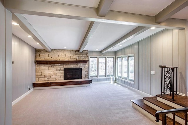 unfurnished living room featuring beamed ceiling, recessed lighting, carpet flooring, a fireplace, and baseboards