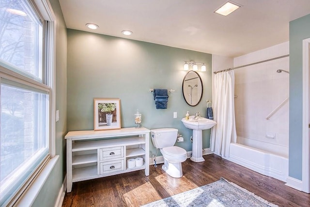 full bath with a wealth of natural light, a sink, toilet, and wood finished floors