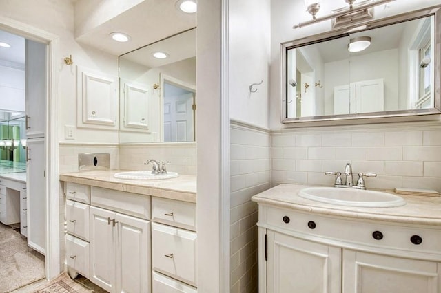 bathroom featuring recessed lighting, two vanities, and a sink