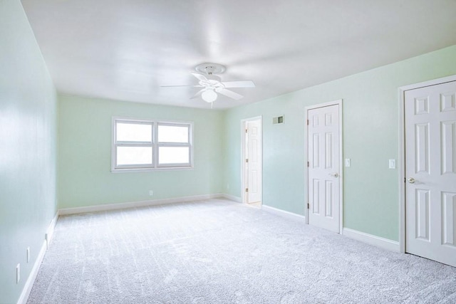 unfurnished bedroom featuring baseboards, carpet floors, visible vents, and a ceiling fan